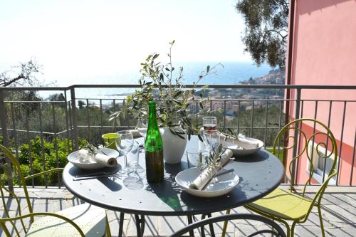 因佩里亚La Torretta的阳台上的桌子上摆放着一瓶葡萄酒和玻璃杯