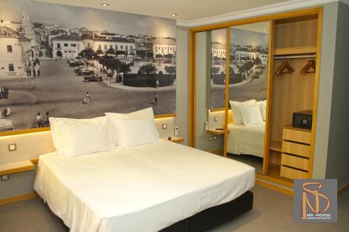 波尔蒂芒NDS Prestige Guest House and Suites - by Rocha Prestige的一间带一张床铺和一张城市海报的卧室
