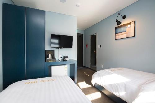 首尔格瑞德酒店的卧室配有白色的床和蓝色的墙壁