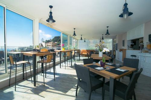 滨海自由城费南思比拉特酒店的用餐室配有桌椅和大窗户