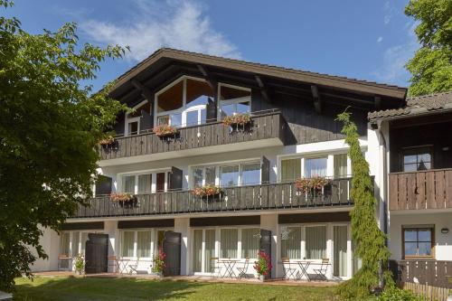 加尔米施-帕滕基兴HYPERION Hotel Garmisch - Partenkirchen的公寓大楼设有阳台和窗户。