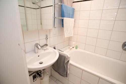 杜塞尔多夫Apartement mit Dachterrasse - bei Curth klingen - Teilen Sie uns Ihre Ankunfszeit mit的白色的浴室设有水槽和浴缸。