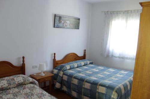 伊格拉德拉谢拉Casa Rural El Tejar的一间卧室设有两张床和窗户。