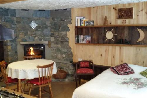 VerrayesTaverna Semon的一间卧室设有石制壁炉、桌子和椅子。