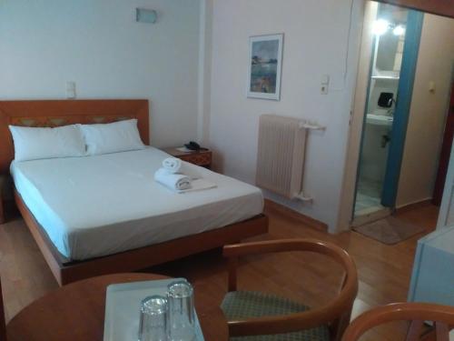 SkaramangásGlaros的酒店客房带一张床、一张桌子和椅子