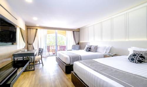 芭东海滩Phuket Graceland Resort and Spa的酒店客房配有两张床和一张书桌