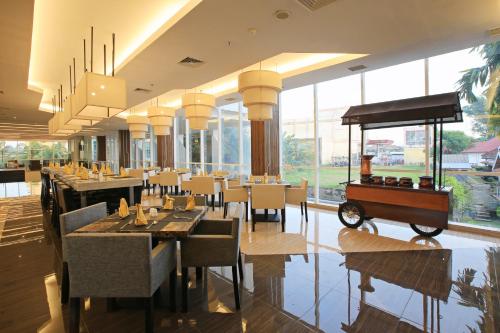 占碑市Luminor Hotel Jambi Kebun Jeruk By WH的一间设有桌椅的餐厅,地面上设有一辆车