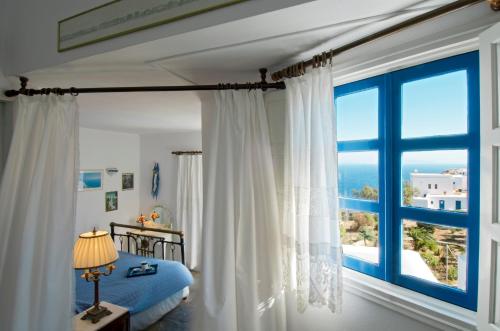 乔拉弗雷恩多斯佩格多斯公寓式酒店的一间卧室设有一张床和一个大窗户