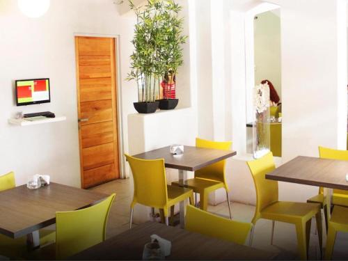 奇廉拉斯特拉扎快捷酒店的用餐室配有木桌和黄色椅子