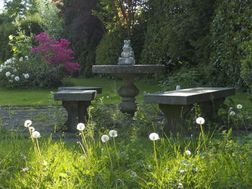 林道拉纳民宿的花园中的喷泉,花园中设有两个石凳