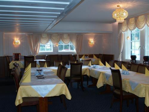 巴特伊堡皇家花园酒店的用餐室配有桌椅和黄色桌布