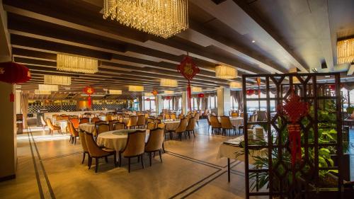 阿尔福维尔Hôtel Huatian Chinagora的用餐室配有桌椅和吊灯。