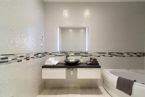 拉戈斯Porto de Mos Golf & Beach B&B AL-40312的一间带水槽、浴缸和镜子的浴室