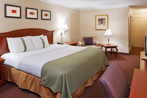 Warren沃伦金祖阿坝假日酒店 - 阿勒格尼的酒店客房带一张大床和一把椅子