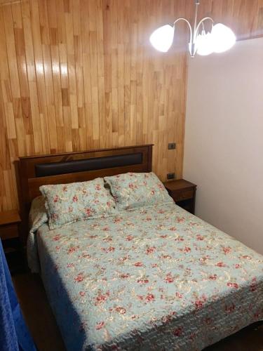 奇廉Cabañas Alto Nativo的一间卧室配有一张带花卉棉被的床