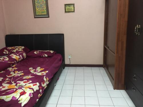 吉隆坡载哈公寓的一间卧室配有一张带紫色棉被的床