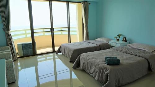 班佩410罗勇贵宾公寓的卧室设有两张床,享有海滩美景