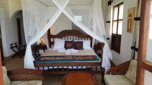 南威兰戈兰戈海滩简易别墅酒店的一间卧室配有一张带天蓬的床