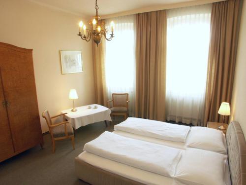 维也纳安塞尔复古客房酒店的酒店客房带两张床和一张桌子以及椅子。
