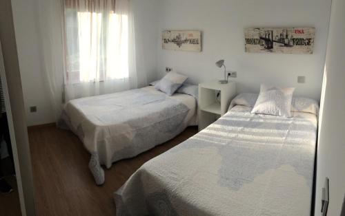 卡德里斯Los Pinos de Cardes的一间卧室设有两张床和窗户。