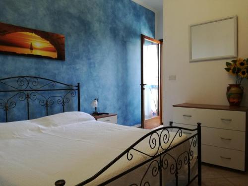 莫尔恰诺迪莱乌卡Casa a due passi dal mare Salento的一间卧室配有一张蓝色墙壁的床
