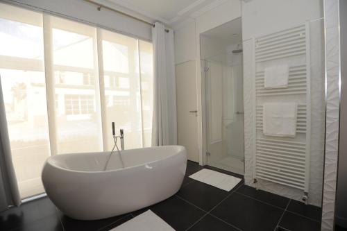 蓬托尔松Hôtel Victor Hugo的带窗户的浴室内的白色浴缸
