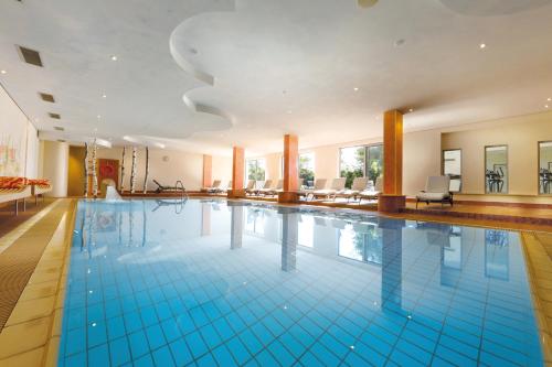 弗罗伊登施塔特格鲁纳森林酒店的铺有蓝色瓷砖的大型游泳池