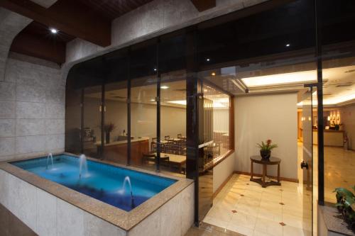 圣保罗蒙克洛亚酒店的一座大型游泳池,位于一座拥有玻璃墙的建筑中