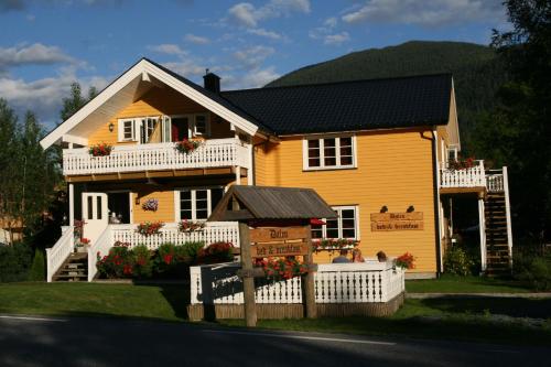 达伦达伦住宿加早餐酒店的黄色房子前面有标志