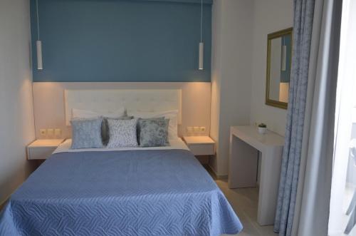 斯塔里斯Levante Sea View Studios的一间卧室配有一张带蓝色床单和枕头的床。