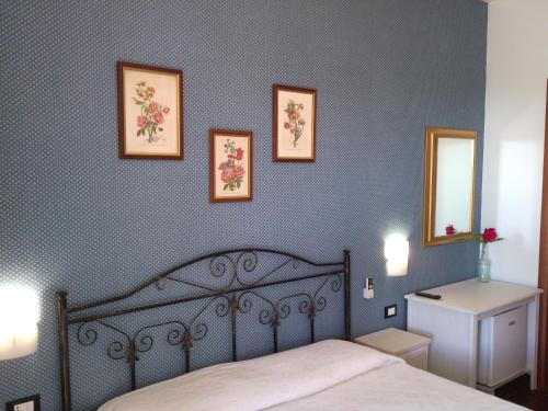 维耶斯泰B&B Villa Makkalè的卧室配有一张床,墙上有三幅照片