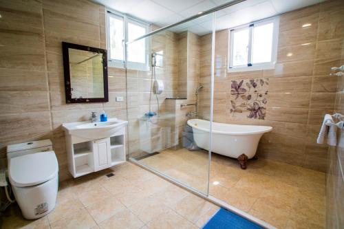 Fushan海水蓝民宿的带浴缸、卫生间和盥洗盆的浴室