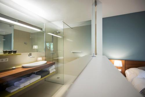 卡尔达罗祖希拉设计酒店的一间带玻璃淋浴和水槽的浴室