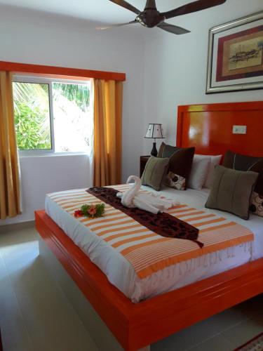 普拉兰海军上将别墅的一间卧室配有一张带橙色和白色毯子的大床