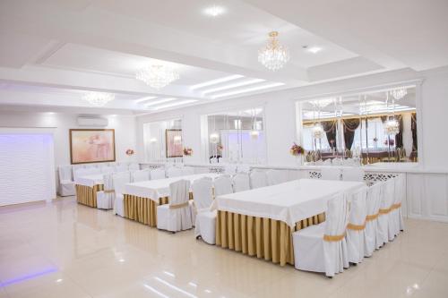 卡缅涅茨-波多利斯基Boutique Hotel Deluxe的白色的房间,配有白色的桌子和白色的椅子