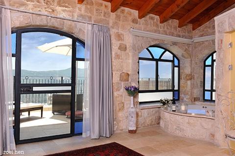 萨法德老城客栈酒店的带浴缸和大窗户的大浴室