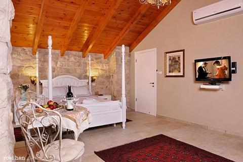 萨法德老城客栈酒店的一间带桌子的客厅和一间带床的房间