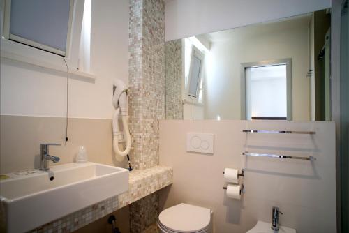 滨海库普拉Hotel Baia Marina的白色的浴室设有水槽和卫生间。
