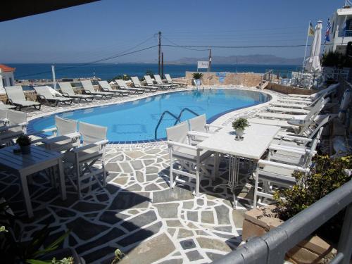 迈加洛丘里The Milos的一个带白色椅子和桌椅的游泳池