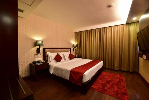 贾姆谢德布尔Hotel JIVA的酒店客房,配有一张带红色毯子的床