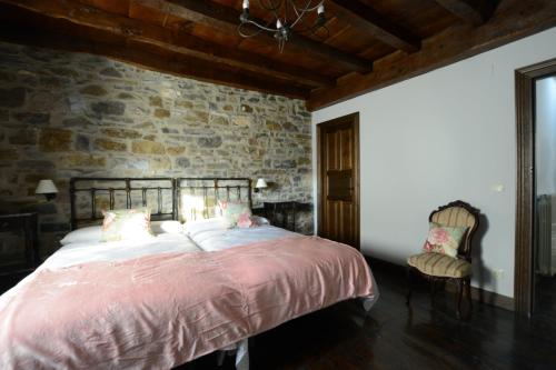 苏维里Txantxorena的一间卧室设有一张大床和石墙