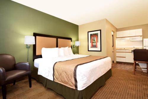 亚特兰大Extended Stay America Select Suites - Atlanta - Cumberland Mall的酒店客房带一张大床和一把椅子