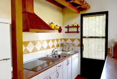 纳瓦孔塞霍Casa Valeriana的厨房配有水槽和炉灶 顶部烤箱