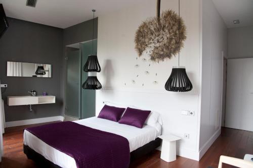 格拉纳达孔湖酒店的一间卧室配有一张带紫色枕头的大床