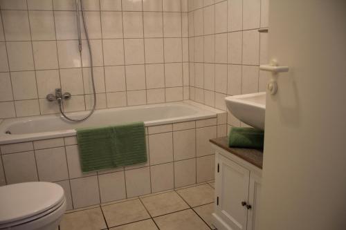 韦瑟灵Apartment-Koeln-Bonn, Ihr Zuhause auf Zeit.的带浴缸、卫生间和盥洗盆的浴室