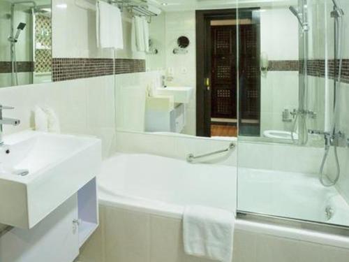 迪拜阿拉伯庭院水疗酒店的带淋浴和盥洗盆的白色浴室