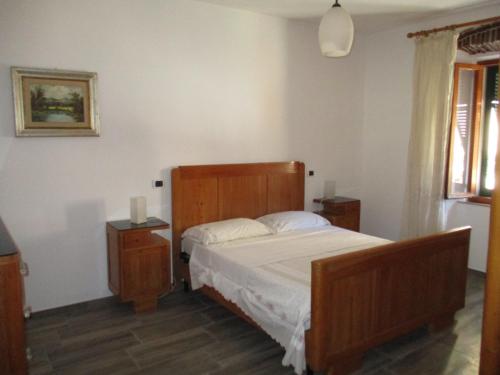 阿祖罗港Casa Porto Azzurro的一间卧室配有一张带木制床头板的床