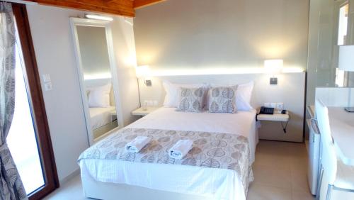 欧拉努波利斯Athos Guest House Pansion的卧室配有带枕头的大型白色床
