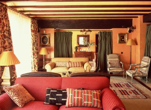 NavalonguillaRemanso de Gredos的客厅配有红色的沙发和椅子