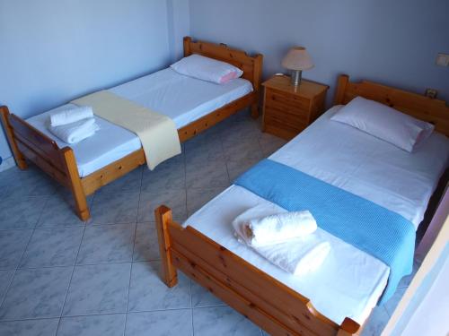克拉默特Keramoti Villa Magnolia的一间铺有瓷砖地板的卧室,配有两张床和一盏灯。